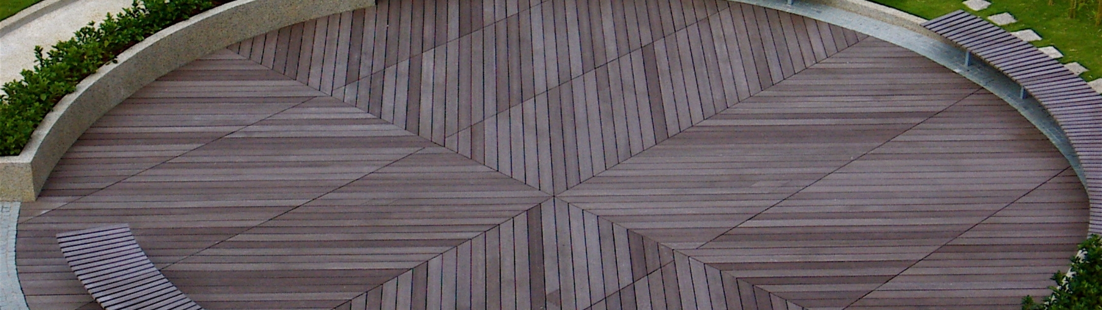 Curved composite decking installed in a public plaza featuring custom geometric deck patterns and durable low-maintenance composite deck boards.