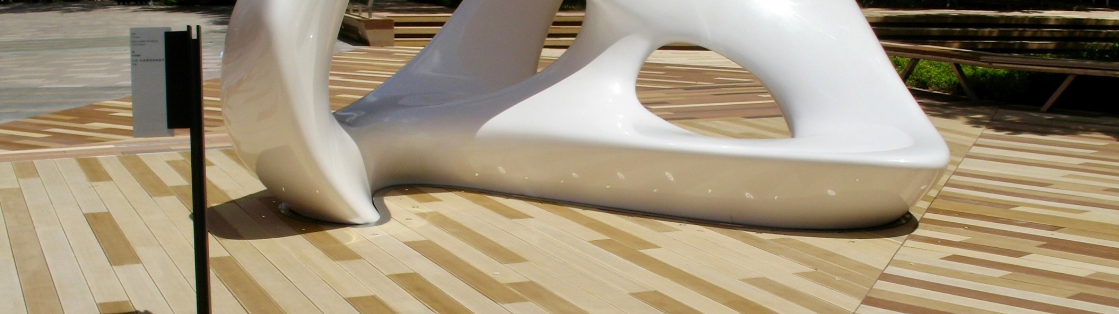 Premium composite decking with custom architectural deck patterns surrounding a modern public art installation in an urban landscape.