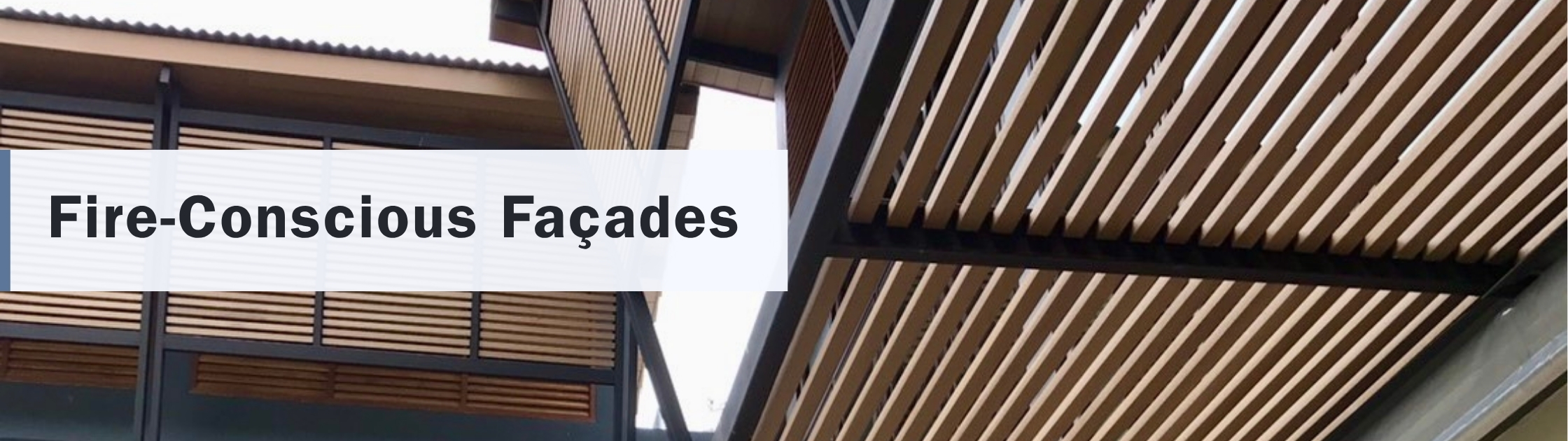 Fire-conscious architectural façade featuring wood-look composite cladding with durable, low-maintenance, fire-resistant exterior screening for modern commercial buildings.