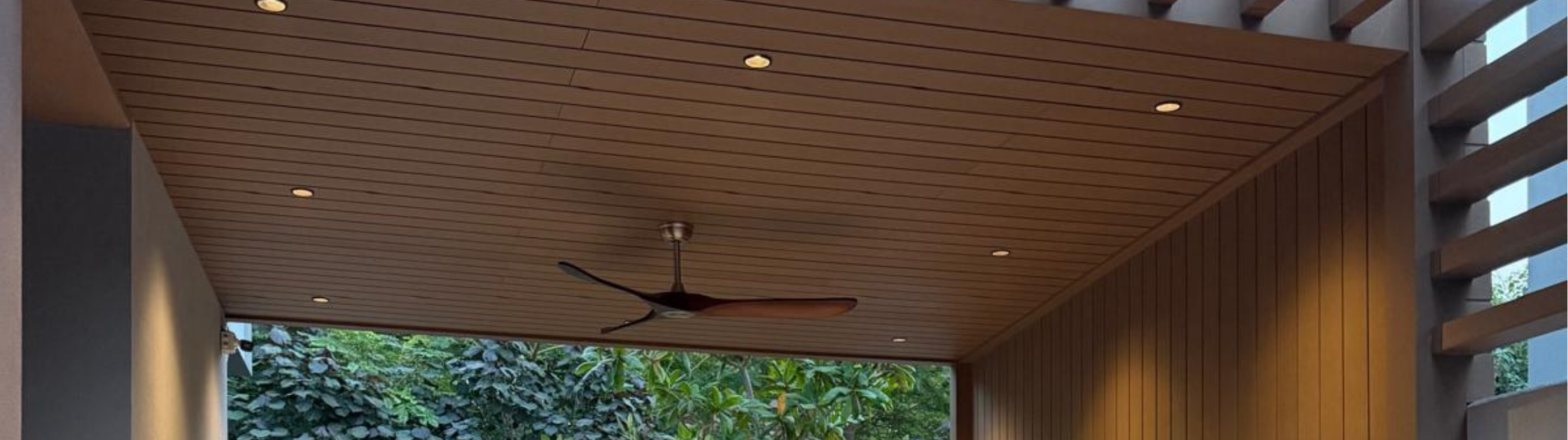 Outdoor living space with wood-look composite ceiling panels, recessed lighting, and ceiling fan for a warm modern aesthetic
